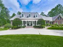 Inviting brick home boasts a manicured lawn, columned porch, and symmetrical landscaping creating stunning curb appeal at 275 Frances Rd, Canton, GA 30114