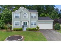 Charming two-story home with a well-manicured lawn and attached two-car garage at 5859 Bellingrath Way, Lithonia, GA 30058