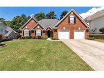 Charming single-Gathering home featuring a well-manicured lawn, brick facade, and a two-car garage at 960 River Valley Dr, Dacula, GA 30019