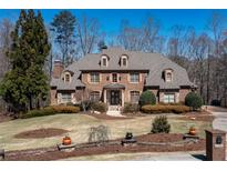 Beautiful two-story brick home with manicured landscaping, dormer windows, and a welcoming front entrance at 120 Kettering Trce, Tyrone, GA 30290