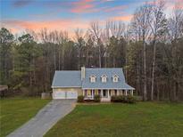 Charming home with a well-manicured lawn and a two-car garage, surrounded by lush trees at 118 Hunters Pl, Villa Rica, GA 30180