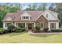 Charming home featuring a stone facade, wood shutters, and a covered front porch at 1825 Epperson Rd, Canton, GA 30115