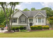 Charming two-story home with manicured lawn, lovely shrubbery, and a mix of vinyl and brick exterior at 2180 Oakpointe Ct, Buford, GA 30519