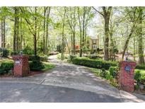 Long driveway leading to a home surrounded by lush trees and landscaping at 386 Collegiate Dr, Powder Springs, GA 30127