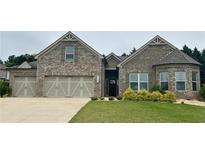 Charming brick home with a three-car garage, well-manicured lawn and lovely landscaping at 3925 Sierra Knolls Ct, Cumming, GA 30040