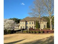 Beautiful brick home with manicured lawn, mature trees, and meticulously maintained landscaping at 105 New Castle Ln, Tyrone, GA 30290
