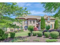 Stately brick home with lush landscaping and mature trees creating beautiful curb appeal at 105 New Castle Ln, Tyrone, GA 30290