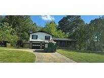 Two story home with a well manicured lawn and a two-car garage, but also a construction dumpster at 382 Plantation Blvd, Lawrenceville, GA 30046