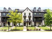 Charming townhomes boast a mix of white brick and gray siding, complemented by well-manicured lawns at 135 Climbing Ivy Cir, Fayetteville, GA 30214