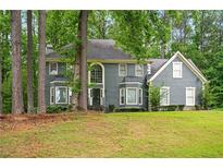 Charming two-story home featuring a well-manicured lawn, mature trees, and a classic facade at 1256 Spring Park Sw Dr, Atlanta, GA 30311