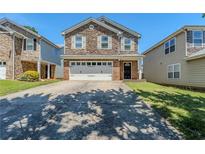 Two-story home with stone and brick front, attached two-car garage, and extended driveway at 1436 Arbor Place Dr, Morrow, GA 30260