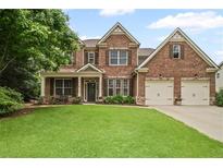 Charming two-story brick home with a lush green lawn and two-car garage at 2955 Pleasant Valley Trl, Cumming, GA 30028