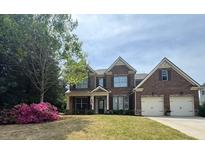 Charming two-story brick home with a well-manicured lawn and attached two-car garage at 2955 Pleasant Valley Trl, Cumming, GA 30028
