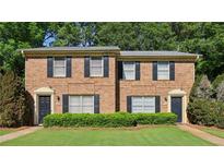 Charming brick townhome with black shutters, green grass, and neatly trimmed bushes at 373 Dixie Ct, Lawrenceville, GA 30046