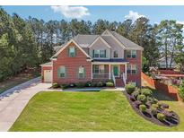 Charming brick home with green shutters, a front porch, and a beautifully landscaped yard at 1829 Alcovy Shoals Blf, Lawrenceville, GA 30045
