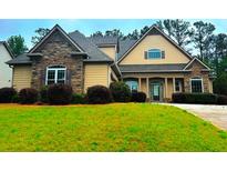 Charming home with a combination of stone and siding, complemented by a lush green lawn and mature trees at 4060 San Marco Way, Douglasville, GA 30135