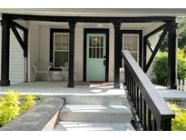 Inviting front porch with a striking teal door and ample seating area at 1608 Carroll Nw Dr, Atlanta, GA 30318