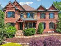 Beautiful brick home featuring stone accents and a well-manicured lawn and flowering shrubs at 3282 Green Farm Trl, Dacula, GA 30019
