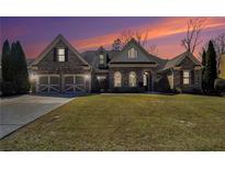 Charming brick home with a two-car garage and manicured lawn, beautifully lit at dusk at 448 Hanover Drive, Villa Rica, GA 30180