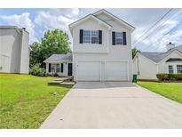 Charming two-story home featuring a two-car garage and well-maintained front yard at 4889 Hidden Creek Pl, Decatur, GA 30035