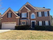 Charming two-story brick home featuring black shutters and an attached two car garage at 1425 Turtle Dove Ln, Lawrenceville, GA 30043