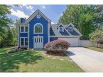 Charming blue two-story home with a well-manicured front yard and white trim at 1930 Huntcliff Dr, Lawrenceville, GA 30043