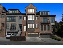 Attractive multi-story townhome with brick and gray siding, manicured landscaping, and attached garages at 2172 Peach Se Ln, Smyrna, GA 30080