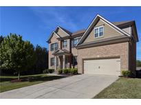 Charming two-story brick home with manicured lawn, a two-car garage and inviting curb appeal at 3204 Ivy Farm Path, Buford, GA 30519
