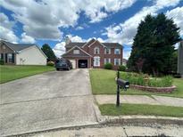 Charming brick home with a two-car garage, manicured lawn, and a neatly maintained front yard at 525 Dunagan Dr, Lawrenceville, GA 30045