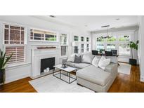 Bright living room features a modern fireplace, large windows, and a comfortable gray sectional sofa at 653 N Highland Ne Ave # 3, Atlanta, GA 30306