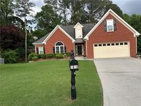 Charming single-Gathering home with a well-manicured lawn, brick facade, and a two-car garage at 1010 Capella Creek Way, Grayson, GA 30017