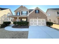 Two-story brick front home featuring a two car garage and well manicured landscaping at 2378 Misty Ivy Ct, Buford, GA 30519