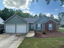 Charming single Gathering home with light blue siding, brick accents, two-car garage and manicured lawn at 4811 Lake Park Ter, Acworth, GA 30101