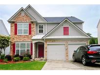 Charming two-story home with stone accents, red shutters, and attached two-car garage at 634 Friars Head Dr, Suwanee, GA 30024