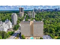 Stunning aerial view showcasing a luxury high-rise condo building amidst lush greenery and a vibrant cityscape at 2479 Peachtree Ne Rd # 1801, Atlanta, GA 30305