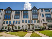 Charming townhome featuring a light brick facade, multiple windows and well maintained landscaping at 6790 Encore Blvd, Sandy Springs, GA 30328