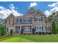 Beautiful two-story home featuring brick and stone facade, manicured lawn, and dark window shutters at 859 Heritage Lake Way, Grayson, GA 30017