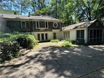 Charming home featuring a stone-accented driveway, screened-in porch, and unique architectural details at 181 Eureka Ne Dr, Atlanta, GA 30305