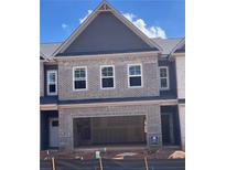 New construction townhome featuring a brick facade, an attached garage, and black roof at 3106 Marbella Cir # 3, Kennesaw, GA 30152