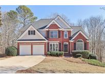Beautiful two-story home boasts a brick facade, two-car garage, and meticulously maintained landscaping at 5034 Hickory Hills Dr, Woodstock, GA 30188