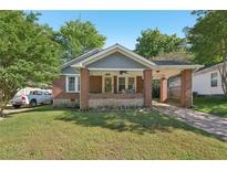 Charming brick home with a covered front porch and a well-maintained lawn at 1841 Thompson Ave, Atlanta, GA 30344