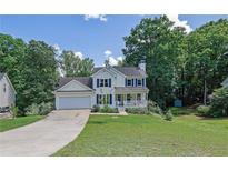Charming two-story home with a manicured front yard and a welcoming porch at 7155 Bannister Park Ln, Cumming, GA 30028