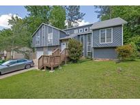 Beautiful two-story home with gray siding, stone accents, and a well-manicured lawn at 2673 Deerfield Sw Cir, Marietta, GA 30064