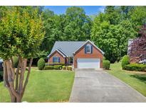 Charming single-story brick home with a well-manicured lawn and attached garage at 415 Stephanie Ct, Stockbridge, GA 30281