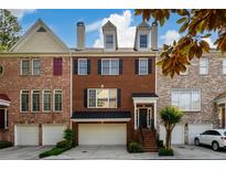 Charming brick townhome with a two-car garage and a well-manicured front yard at 10090 Jones Bridge Rd # 2, Alpharetta, GA 30022