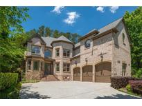 Stunning brick home featuring a three car garage and well-manicured landscaping at 3680 Milton Park Dr, Alpharetta, GA 30022