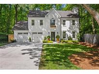 Stunning two-story home with a manicured lawn, attached garage, and classic white painted brick exterior at 4331 Volnay Ne Ct, Marietta, GA 30066