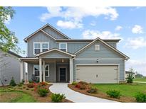 Charming two-story home featuring a welcoming front porch and well-manicured landscaping at 2010 Moonlight Path, Covington, GA 30016