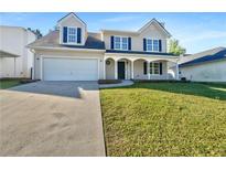Charming two-story home with a well-manicured lawn, a two-car garage, and a welcoming front porch at 3479 Woodruff Ridge Ln, Loganville, GA 30052