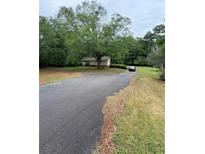 Charming single-story home nestled on a wooded lot with a private driveway and mature shade trees at 4897 Lou Ivy Rd, Peachtree Corners, GA 30096